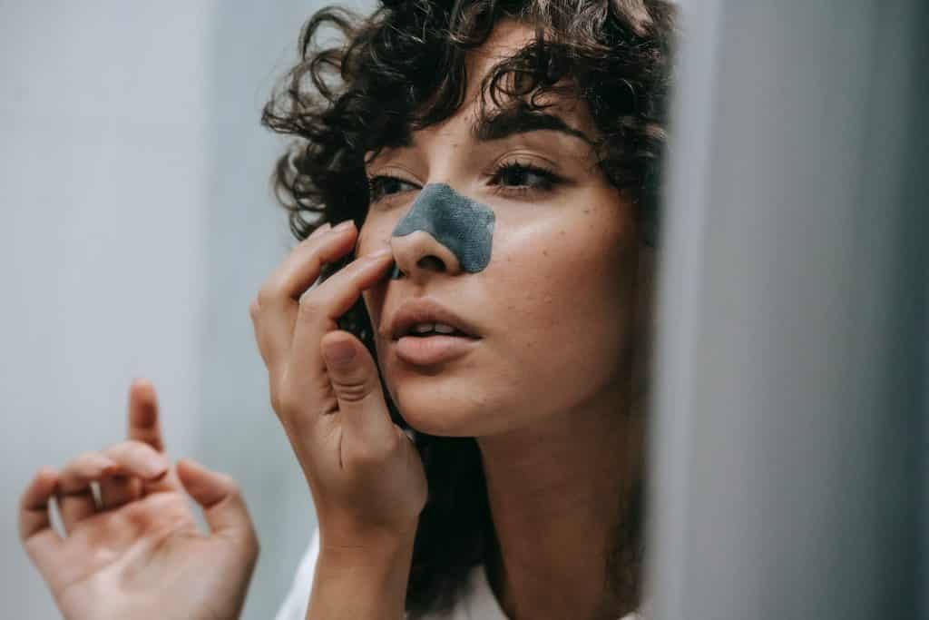 صورة أمرأة تضع ماسك جيلاتين علي أنفها لإزالة الرؤوس السوداء